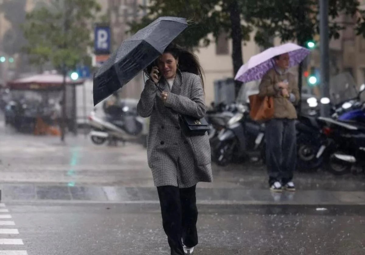 Imagen de archivo de una mujer con un paraguas en un día de lluvia