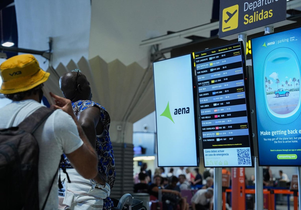 Viajeros en los paneles del Aeropuerto de San Pablo en Sevilla