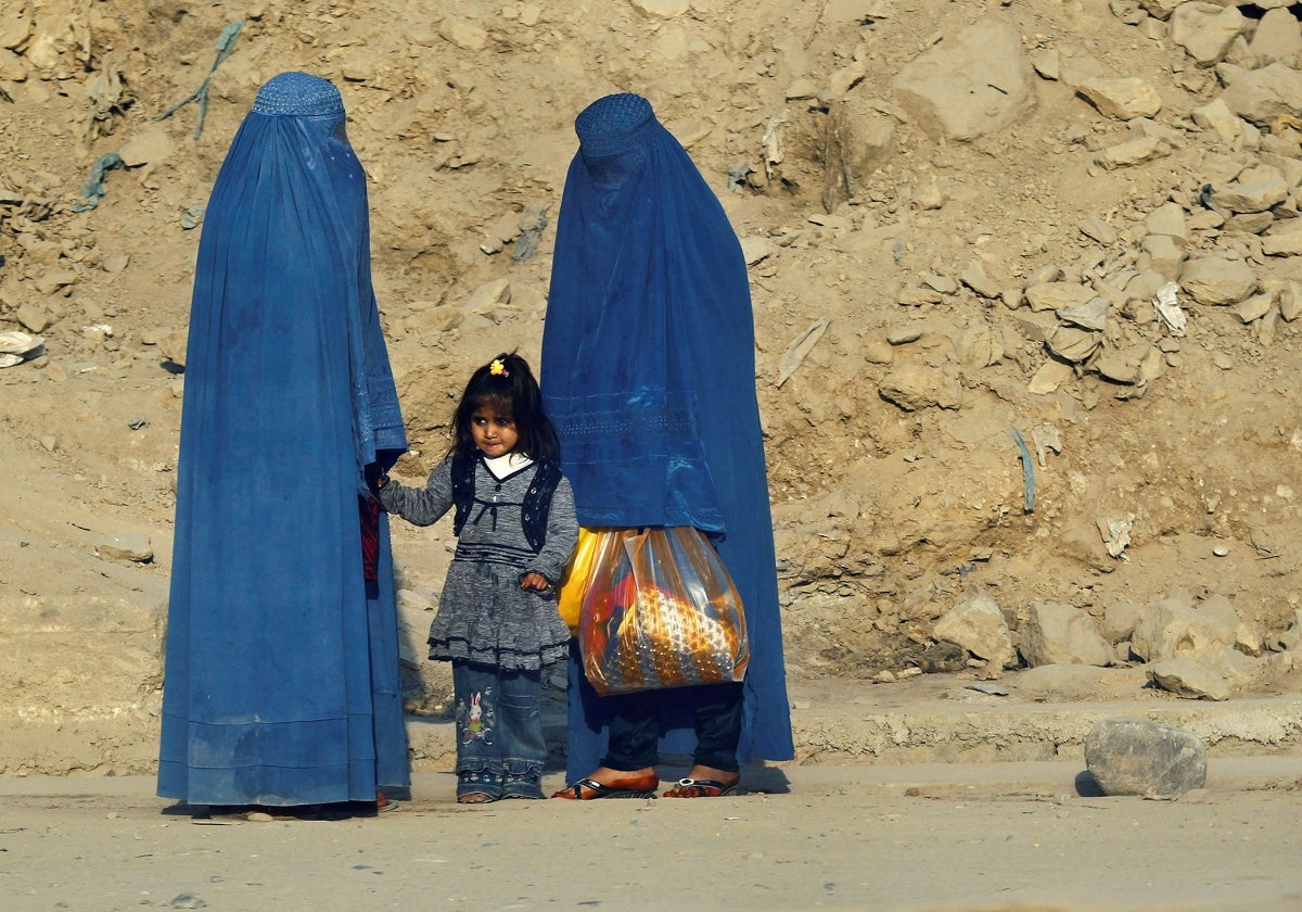 Dos mujeres con burka pasean por las calles de Kabul con una niña