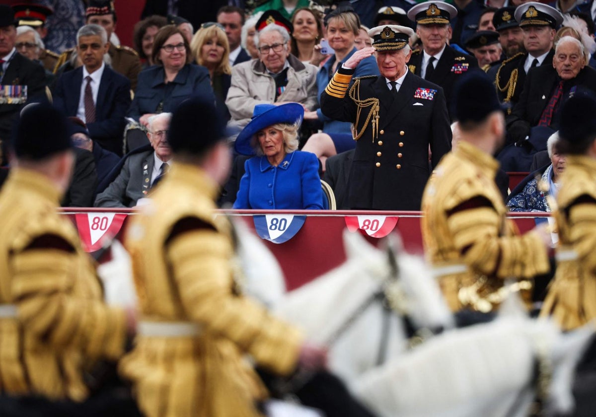 El Rey Carlos III, acompañado de la Reina Camila, saluda durante el desfile del Día de la Victoria, en Londres